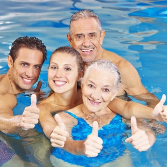 Aquafitness bei Plitsch-Platsch, vier junge und ältere Aqua Fitness Teilnehmer zeigen Daumen hoch