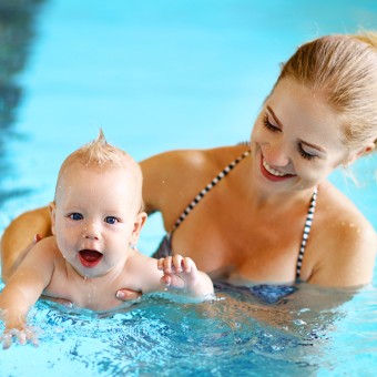 Babyschwimmen bei Plitsch-Platsch, Baby wird von Mama in Schwimmposition gehalten